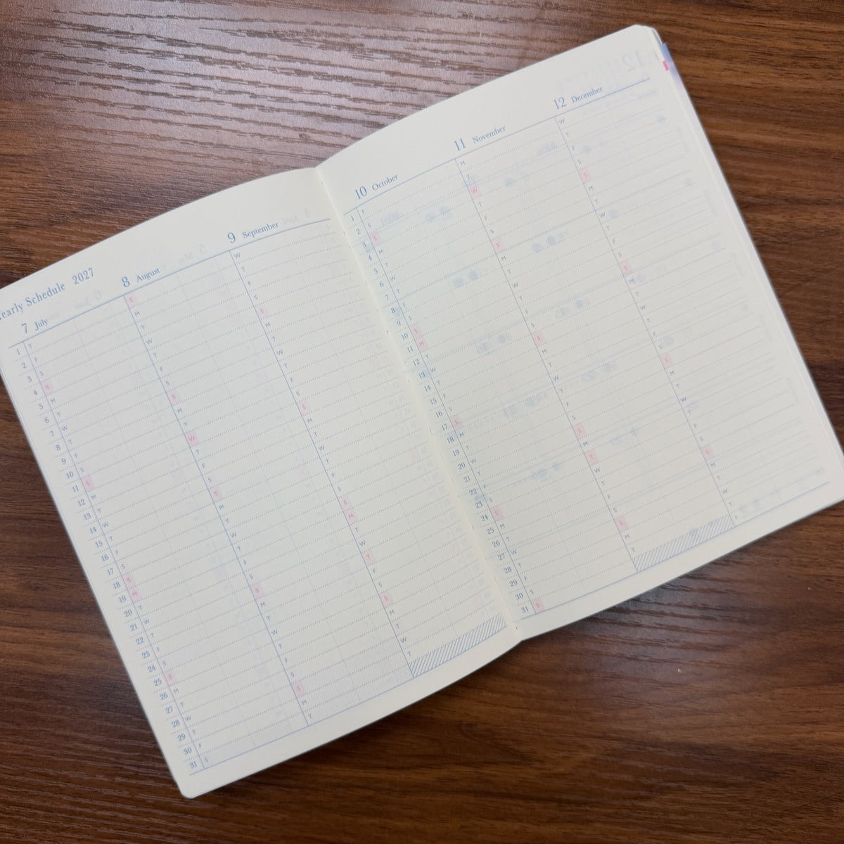 Midori B6 Gradation Day Length Planner open to Yearly Schedule on table