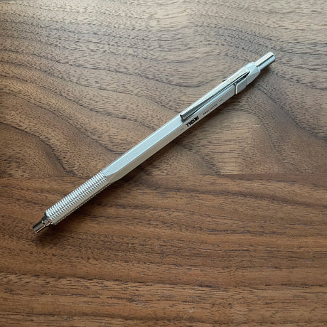 Silver TWSBI Precision Ballpoint Resting atop wood surface