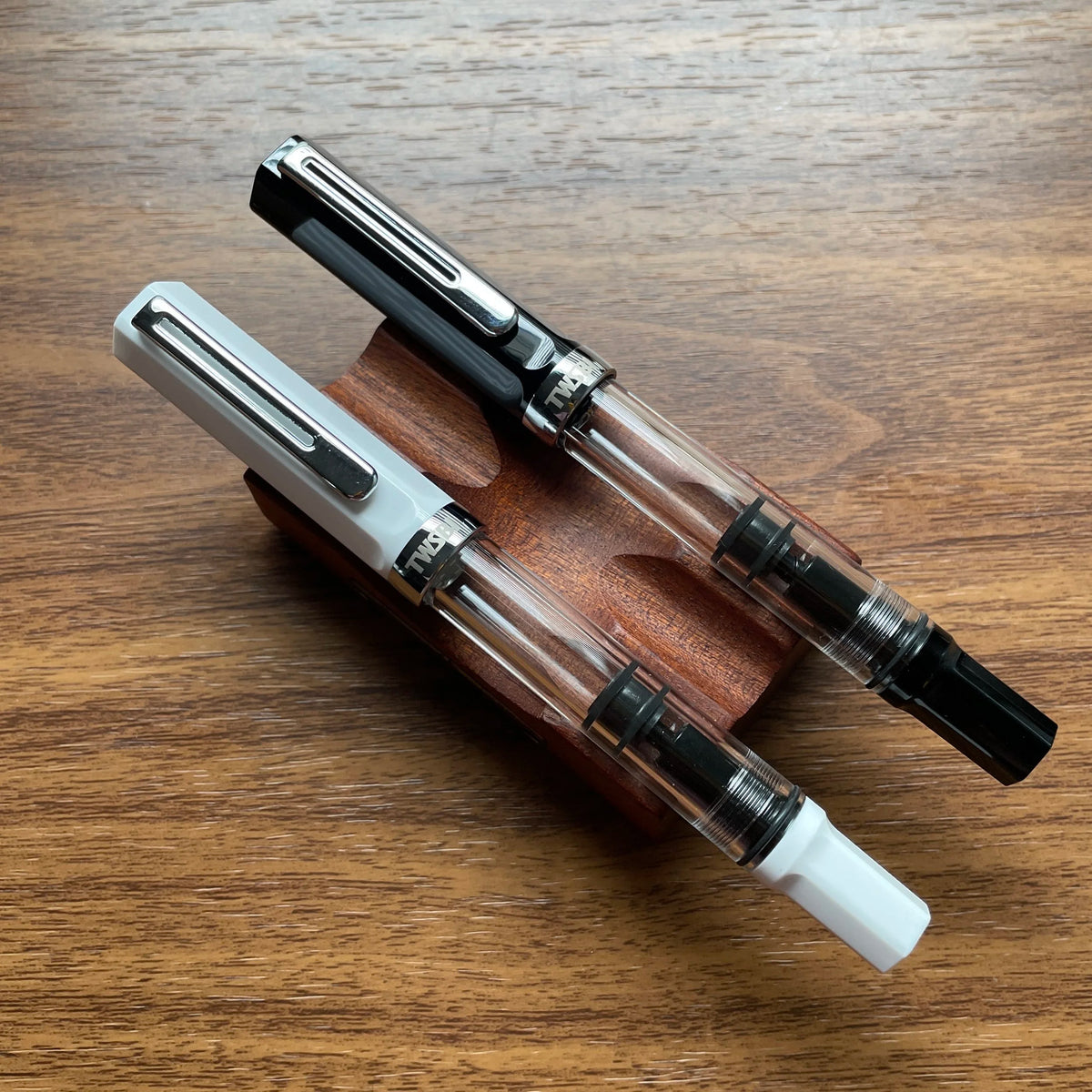 TWSBI ECO Black Fountain Pen Sitting on Pen Stand Next to a White TWSBI ECO Fountain Pen