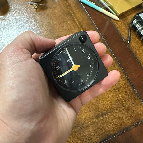 Braun Small Travel Alarm Clock Black in hand for scale