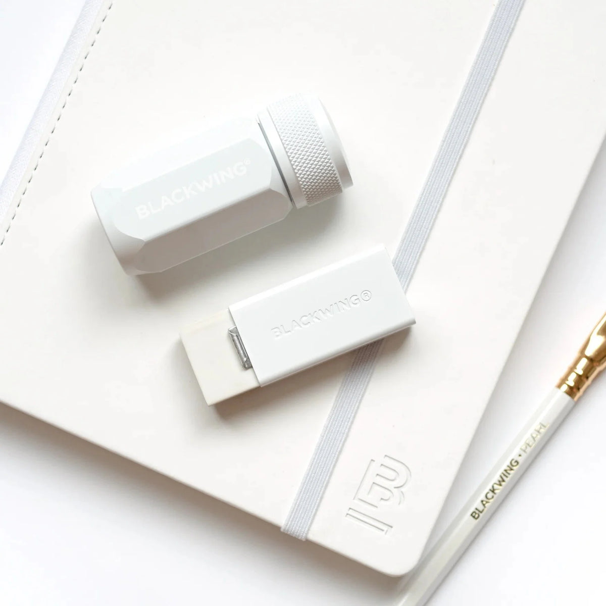 Blackwing Handheld Eraser White on table with sharpener and pencil