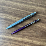 Caran d'Ache 849 Rollerball Pen Diagonally on table alongside 849 Ballpoint