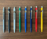 Caran d'Ache 849 Ballpoint Pen Standard Lined up on Desk