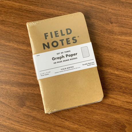 A set of three Field Notes 48 page pocket notebooks with kraft paper covers, graph ruling.