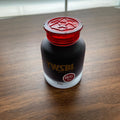 Bottle of TWSBI ink with red cap on a wooden surface