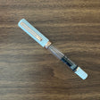 TWSBI White and Rose Gold Fountain pen capped on a wood table 
