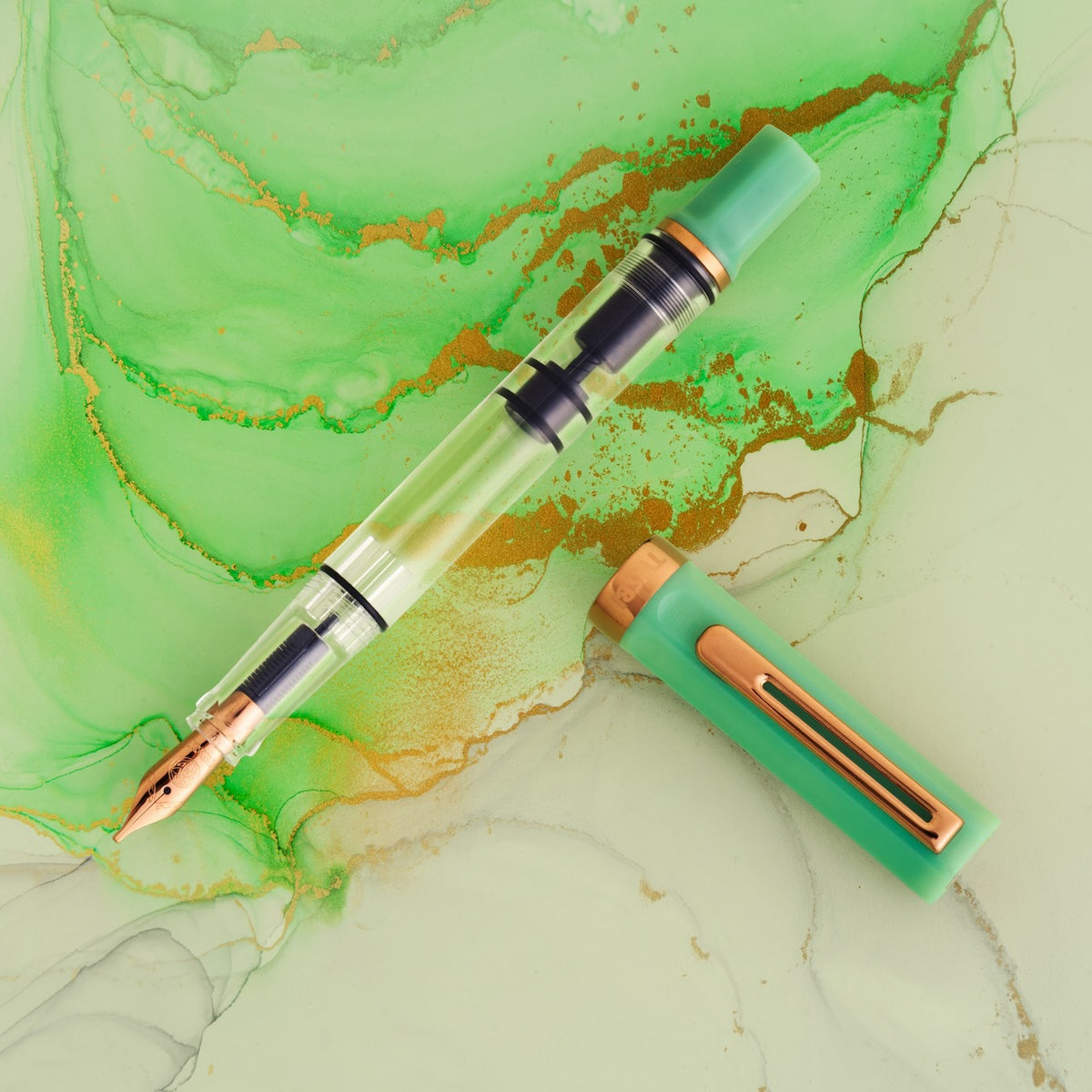 TWSBI ECO Jade Jelly Plus Bronze Fountain Pen uncapped on green Jadeite background 