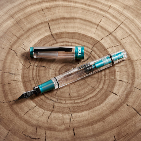 TWSBI Diamond 580 Caribbean Blue + Onyx Fountain Pen Cover Image on Wood