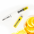 TWSBI ECO Transparent Yellow Fountain Pen Uncapped with Citrus in background 