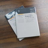 Two stacked NOLTY A5 Notebooks with black covers and 192 white pages, one lined and one grid.