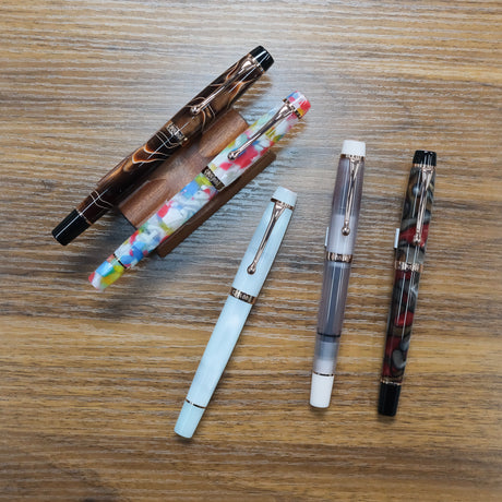 Opus 88 Harmony Fountain Pens displayed on wood table on pen stands