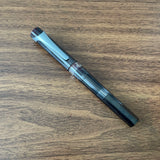 TWSBI Swipe Smoke Fountain Pen Resting on Wood Desk