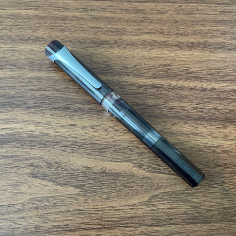 TWSBI Swipe Smoke Fountain Pen Resting on Wood Desk