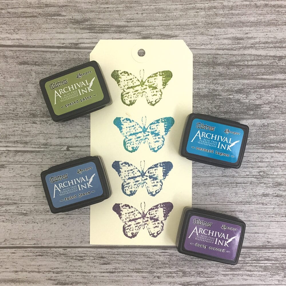Ranger Ink Mini Stamp Pad 4-pack featuring Tim Holz Distress Inks Peeled Paint, Faded jeans, Mermaid Lagoon, and Dusty Concord Colors, showing ink samples on paper