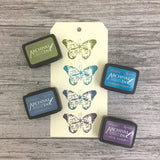 Ranger Ink Mini Stamp Pad 4-pack featuring Tim Holz Distress Inks Peeled Paint, Faded jeans, Mermaid Lagoon, and Dusty Concord Colors, showing ink samples on paper