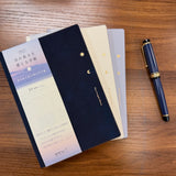 Midori B6 Gradation Day Length Planners in three colors stacked on table