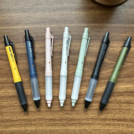 Seven Uni Kuru Toga Alpha Gel Switch mechanical pencils in different colors on a table.