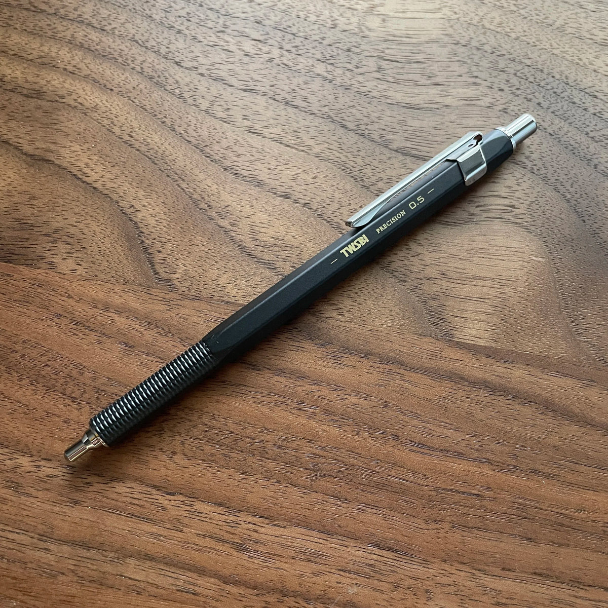 Black TWSBI Precision mechanical pencil Retractable Tip on a wooden surface