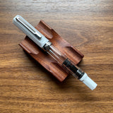 TWSBI ECO White Fountain pen with wooden holder on a wooden surface