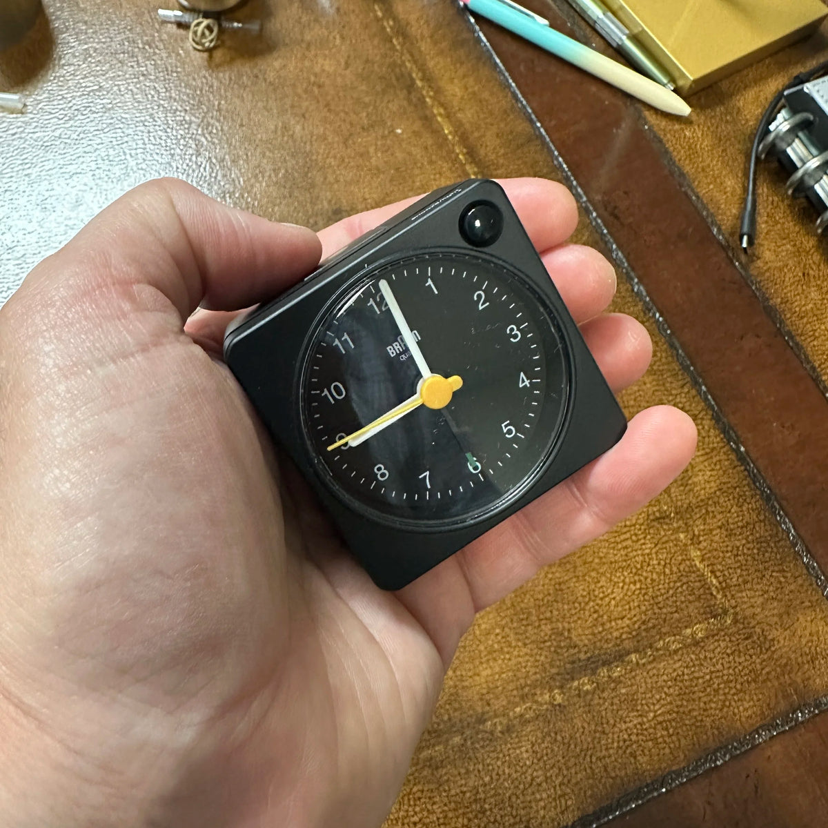 Braun Small Travel Alarm Clock Black in hand for scale