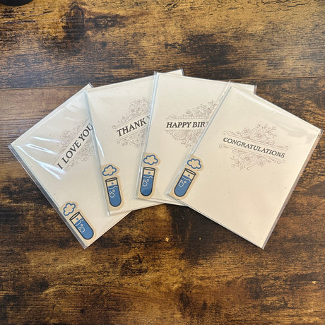 Four individually-packaged letterpress greeting cards from Skylab Letterpress with dark text and a flourish design on thick, off-white paper with messages I Love You, Thank You, Happy Birthday, and Congratulations.