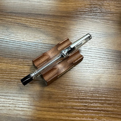 TWSBI Vac700R Fountain Pen in Clear Acrylic Sitting on Wood Background
