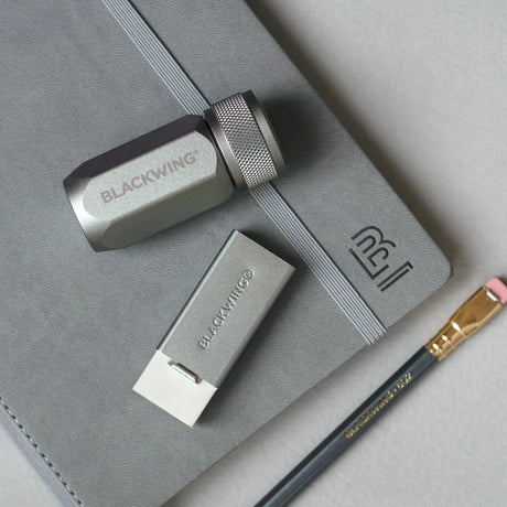 Blackwing Handheld Eraser Grey on table with sharpener and pencil