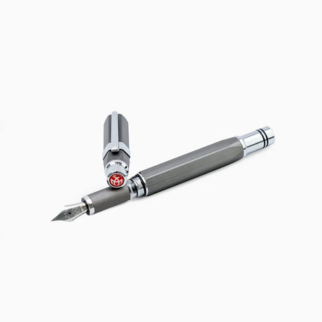 Gunmetal Grey TWSBI Precision fountain pen on a white background uncapped with cap resting on section