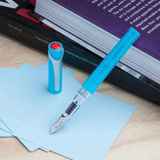 Ice Blue TWSBI Swipe Fountain Pen Uncapped resting on book
